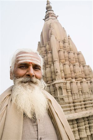 Portrait d'un sâdhu avec un temple à l'arrière-plan, Scindia Ghat, Gange, Varanasi, Uttar Pradesh, Inde Photographie de stock - Rights-Managed, Code: 857-03192997