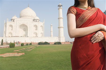 poses in saree for outdoor photography - Mid section view of a woman standing in front of a mausoleum, Taj Mahal, Agra, Uttar Pradesh, India Foto de stock - Con derechos protegidos, Código: 857-03193048