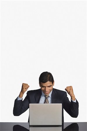 Businessman using a laptop and smiling Stock Photo - Rights-Managed, Code: 857-03554048