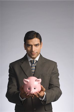 simsearch:630-06722196,k - Portrait of a businessman holding a piggy bank Foto de stock - Con derechos protegidos, Código: 857-03554042