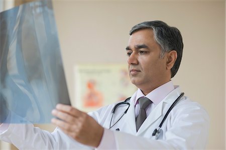 Doctor examining an x-ray report, Gurgaon, Haryana, India Stock Photo - Rights-Managed, Code: 857-03554112