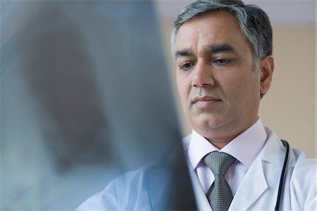 Doctor examining an x-ray report, Gurgaon, Haryana, India Stock Photo - Rights-Managed, Code: 857-03554113