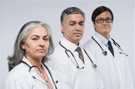 Portrait of a female doctor with two male doctors Foto de stock - Con derechos protegidos, Código: 857-03554127