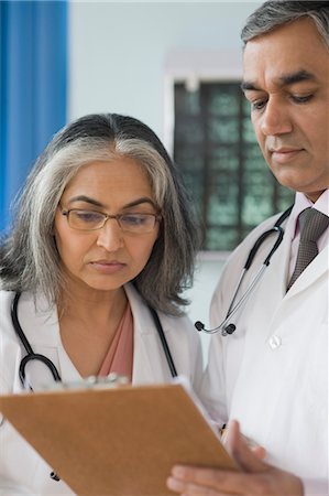 stethoscope check up indian photos - Femme médecin parlant à un médecin, Gurgaon, Haryana, Inde Photographie de stock - Rights-Managed, Code: 857-03554138