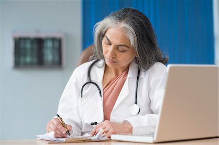 simsearch:857-03554275,k - Female doctor using a laptop and writing prescription, Gurgaon, Haryana, India Fotografie stock - Rights-Managed, Codice: 857-03554146
