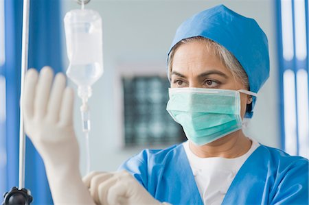 Weibliche Chirurgen setzen auf OP-Handschuhe, Gurgaon, Haryana, Indien Stockbilder - Lizenzpflichtiges, Bildnummer: 857-03554153