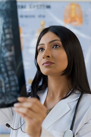 Female doctor examining an x-ray report, Gurgaon, Haryana, India Stock Photo - Rights-Managed, Code: 857-03554198