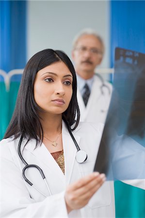 Female doctor examining an x-ray report, Gurgaon, Haryana, India Stock Photo - Rights-Managed, Code: 857-03554233