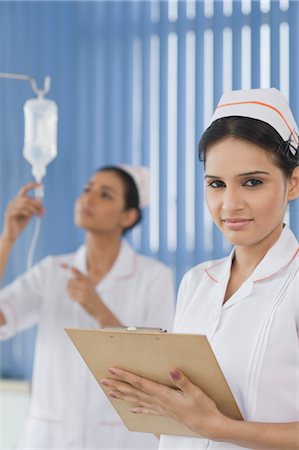 Zwei weiblichen Krankenschwestern Anpassung einer saline Drip, Gurgaon, Haryana, Indien Stockbilder - Lizenzpflichtiges, Bildnummer: 857-03554251