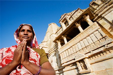 Woman standing in a prayer position in front of a temple, Kumbh Shyam Temple, Chittorgarh, Rajasthan, India Stock Photo - Rights-Managed, Code: 857-03553533