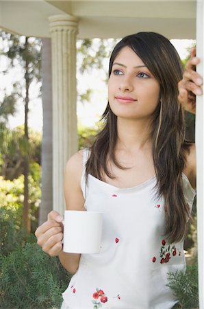 Woman drinking coffee and day dreaming, New Delhi, India Stock Photo - Rights-Managed, Code: 857-03553776