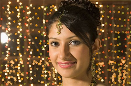 face woman lighting - Woman smiling in front of Diwali decoration Foto de stock - Con derechos protegidos, Código: 857-03553801