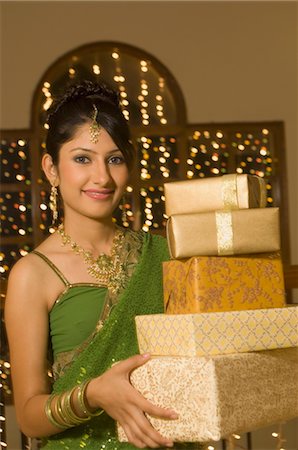 diwali lights photography - Woman holding Diwali gifts and smiling Stock Photo - Rights-Managed, Code: 857-03553803