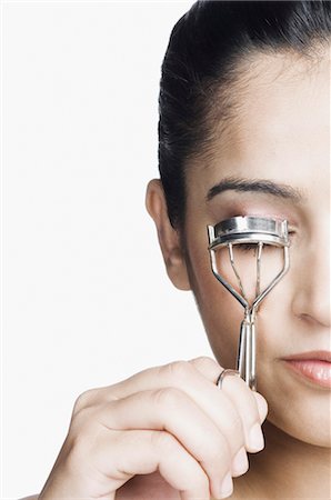 rizador de pestañas - Close-up of a young woman curling her eyelashes with eyelash curler Foto de stock - Con derechos protegidos, Código: 857-03553953