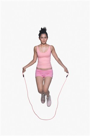 photosindia - Portrait of a young woman jumping rope Foto de stock - Direito Controlado, Número: 857-03553979