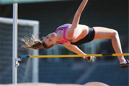 salto em altura - Young Female Athlete Performing High Jump Foto de stock - Direito Controlado, Número: 858-05604667