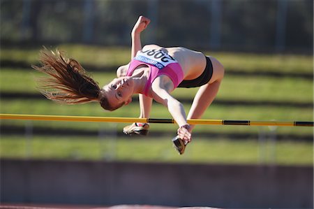 salto em altura - Young Female Athlete Performing High Jump Foto de stock - Direito Controlado, Número: 858-05604681