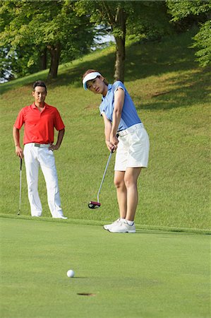 Young Woman Putting Golf Ball Stock Photo - Rights-Managed, Code: 858-06756176