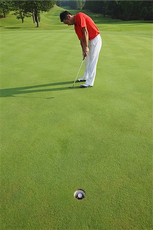 shot a goal - Golfer Putting Golf Ball Into Hole Stock Photo - Rights-Managed, Code: 858-06756170