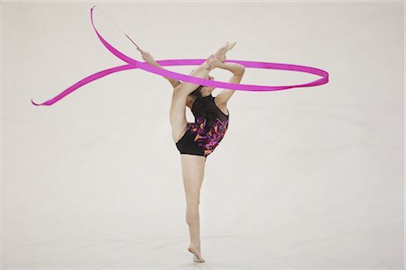 Une jeune fille jouant de gymnastique rythmique avec jambe soulevée Photographie de stock - Rights-Managed, Code: 858-03048907