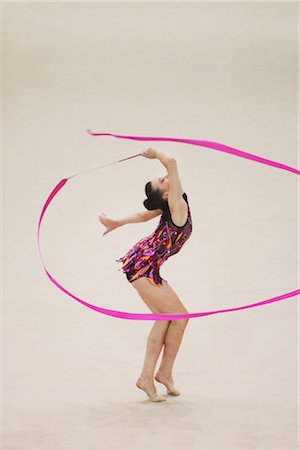 ribbon dancing gymnastics - Side view of a teenage girl performing rhythmic gymnastics with ribbon Stock Photo - Rights-Managed, Code: 858-03048900