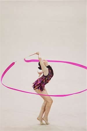 ribbon dancing gymnastics - Side view of a teenage girl performing rhythmic gymnastics with ribbon Stock Photo - Rights-Managed, Code: 858-03048902