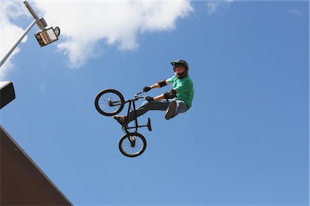 simsearch:625-02266411,k - Man jumping with bicycle against blue sky Foto de stock - Con derechos protegidos, Código: 858-03049528