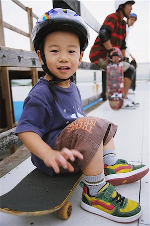 simsearch:858-03799609,k - Kind sitzt auf skateboard Stockbilder - Lizenzpflichtiges, Bildnummer: 858-03799595