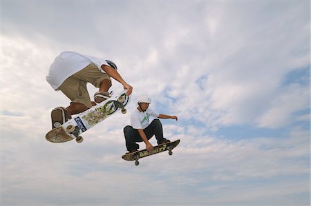 Skateboarders in mid-air Foto de stock - Con derechos protegidos, Código: 858-03799602