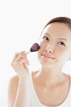 Japanese woman putting on make up Stock Photo - Rights-Managed, Code: 859-06404789