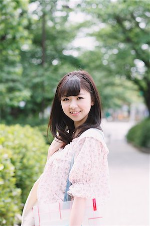 Portrait d'une jeune fille japonaise souriant tout en regardant la caméra Photographie de stock - Rights-Managed, Code: 859-06404835