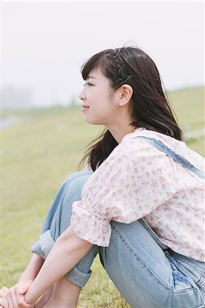 Japanese girl sitting on the grass looking away Stock Photo - Rights-Managed, Code: 859-06404844