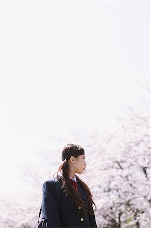 Japanese schoolgirl in her uniform with cherry blossoms in the background Stock Photo - Rights-Managed, Code: 859-06404858