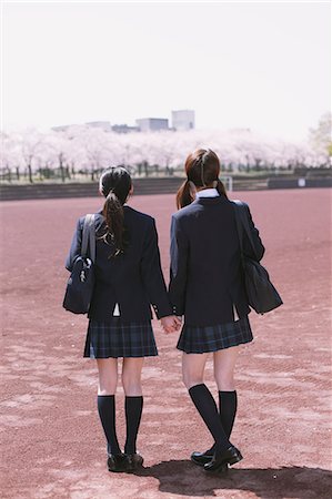 sakura japanese cherry trees - Japanese schoolgirls in their uniforms holding hands while walking away Stock Photo - Rights-Managed, Code: 859-06404853