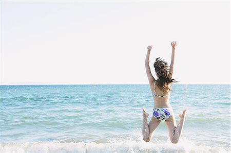 simsearch:859-07845832,k - Japanese woman in a bikini jumping by the sea Foto de stock - Con derechos protegidos, Código: 859-06404888