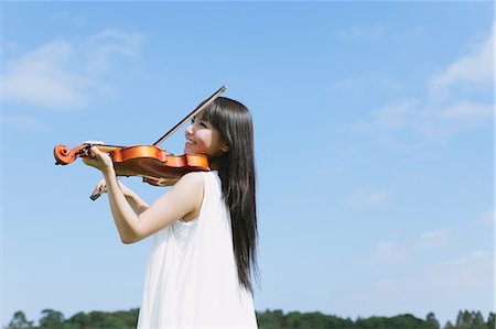 simsearch:6109-06005244,k - Asiatique femme jouant du violon avec ciel bleu en arrière-plan Photographie de stock - Rights-Managed, Code: 859-06404906