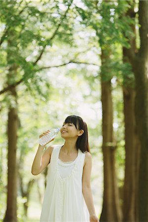 simsearch:859-06404913,k - Asian woman in a white dress drinking water in the woods Stock Photo - Rights-Managed, Code: 859-06404915