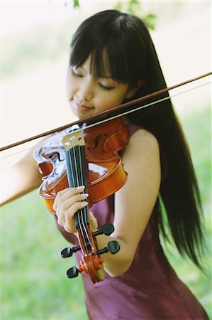 female musicians with long hair - Portrait of an Asian woman playing the violin in a grass field Stock Photo - Rights-Managed, Code: 859-06404910