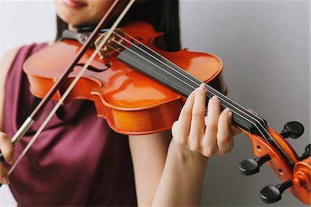 Gros plan d'une femme asiatique vêtue d'une robe pourpre, jouer du violon Photographie de stock - Rights-Managed, Code: 859-06404925