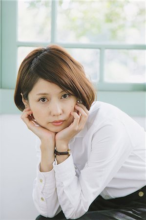 Femme japonaise dans une chemise blanche, s'asseoir et regarder la caméra Photographie de stock - Rights-Managed, Code: 859-06404940