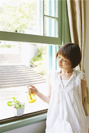 simsearch:859-06404995,k - Japanische Frau in einem weißen Kleid Tränken eine Pflanze vom Fenster Stockbilder - Lizenzpflichtiges, Bildnummer: 859-06404956