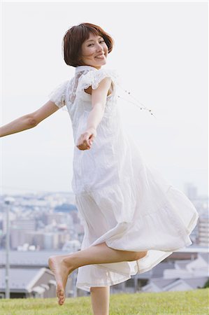 Femme japonaise aux cheveux courts dans une robe blanche sauter pieds nus Photographie de stock - Rights-Managed, Code: 859-06404967