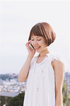 simsearch:859-06404969,k - Japanese woman with short hair in a white dress talking on the phone Fotografie stock - Rights-Managed, Codice: 859-06404963