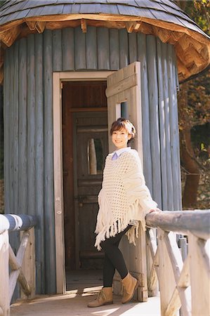 poncho - Japanese woman in a white cardigan leaning against a wooden door Foto de stock - Con derechos protegidos, Código: 859-06404976