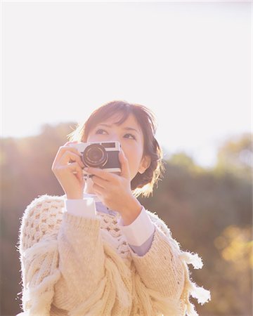 simsearch:622-07519762,k - Portrait of a Japanese woman in a white cardigan holding an old camera Foto de stock - Con derechos protegidos, Código: 859-06404980