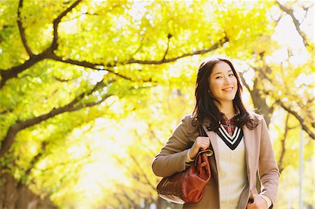 simsearch:859-06404994,k - Femme japonaise avec de longs cheveux regardant la caméra avec des feuilles jaunes en arrière-plan Photographie de stock - Rights-Managed, Code: 859-06404990