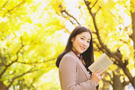 park avenue - Japanische Frau mit langem Haar, Blick in die Kamera halten Sie ein Buch mit gelben Blätter im Hintergrund Stockbilder - Lizenzpflichtiges, Bildnummer: 859-06404991