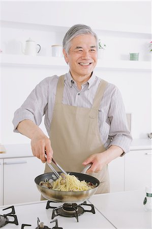 Senior adult man cooking pasta in an open kitchen Photographie de stock - Rights-Managed, Code: 859-06469751