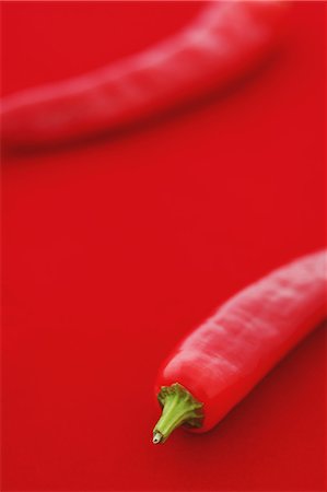 simsearch:622-08893834,k - Chilli peppers on red background Stockbilder - Lizenzpflichtiges, Bildnummer: 859-06470052