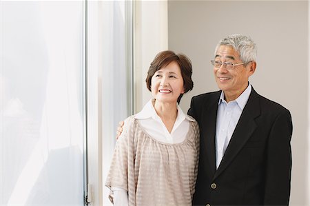 senior asian woman happy - Senior adult couple cuddling while looking outside the window Stock Photo - Rights-Managed, Code: 859-06470200